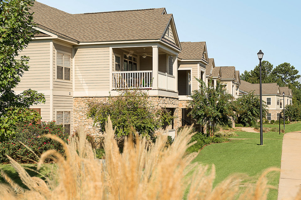 a row of houses in a neighborhood with grass and trees