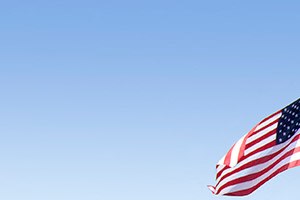 the front of a house with an flag on a pole
