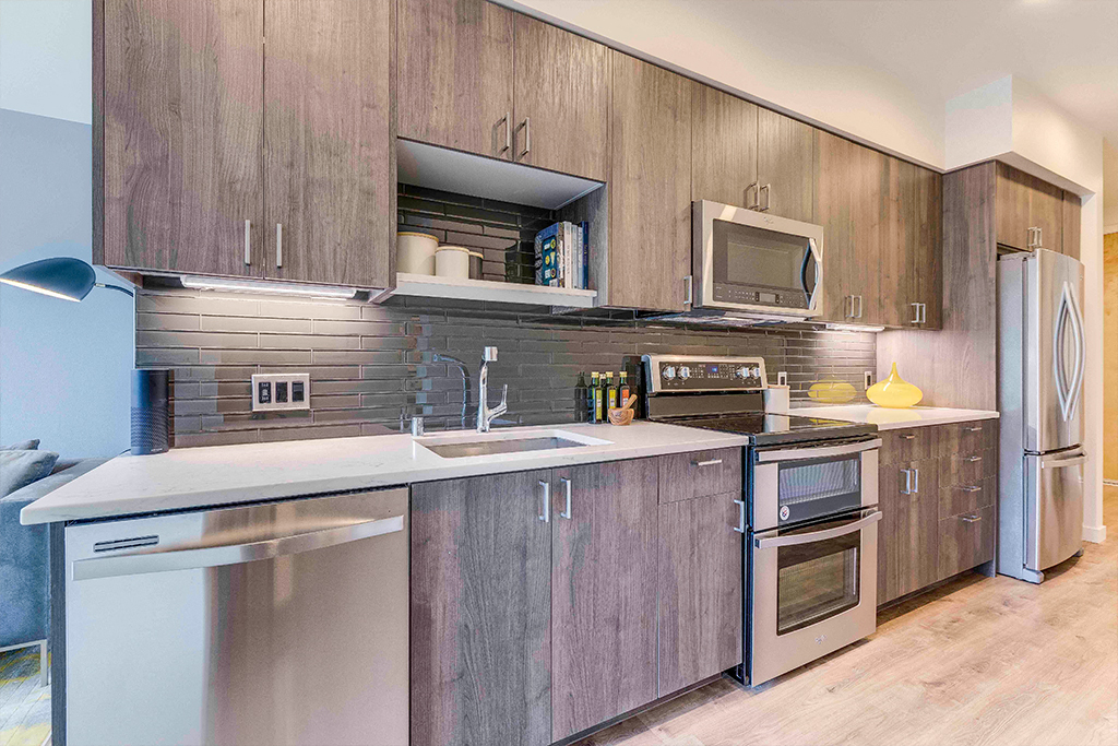 a modern kitchen with stainless steel appliances and wooden cabinets