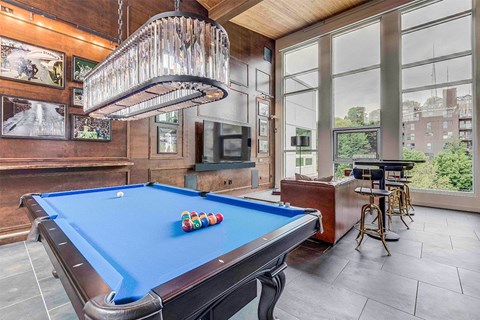 a pool table in a living room with a chandelier
