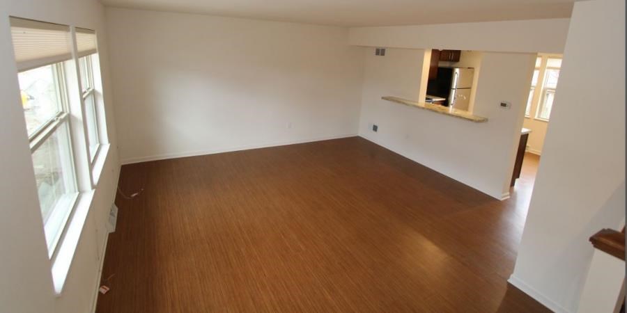 an empty living room with a wooden floor
