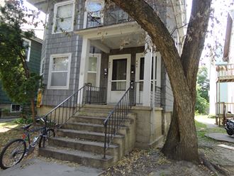 a house with stairs and a bike parked in front of it