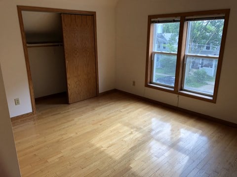 an empty living room with wood floors and a closet