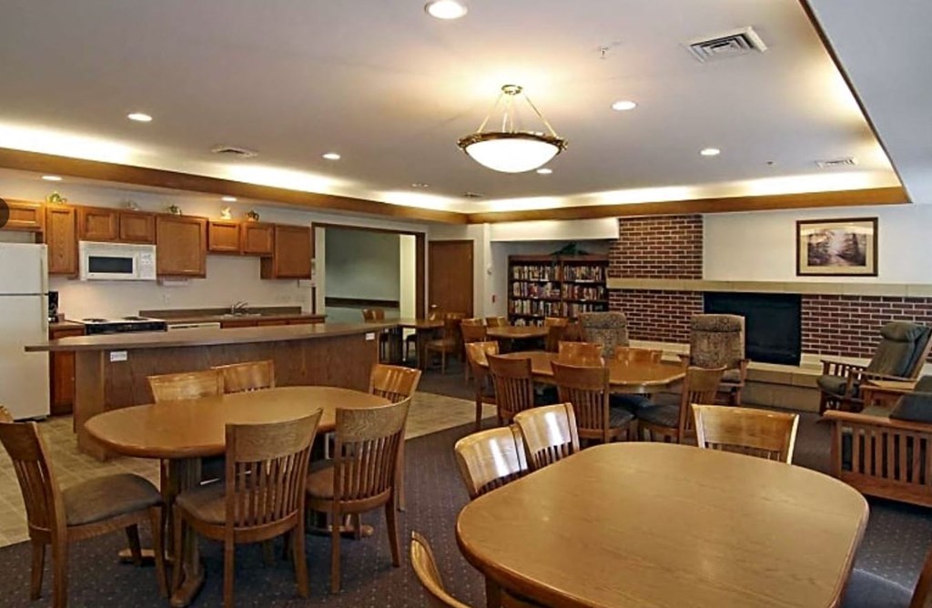 a dining room with tables and chairs and a kitchen