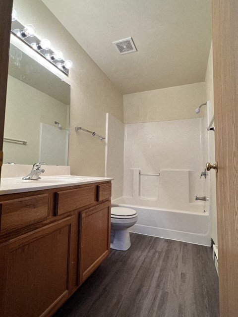 A bathroom with a toilet, sink, and shower.