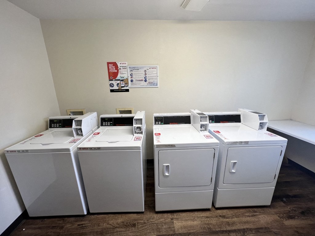 A room with two washing machines and a poster on the wall.