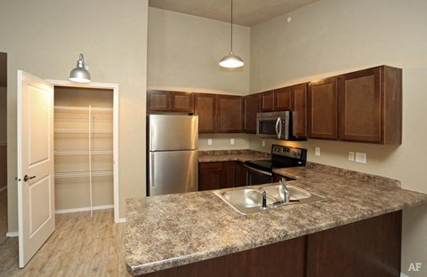 a kitchen with a granite counter top and a stainless steel refrigerator