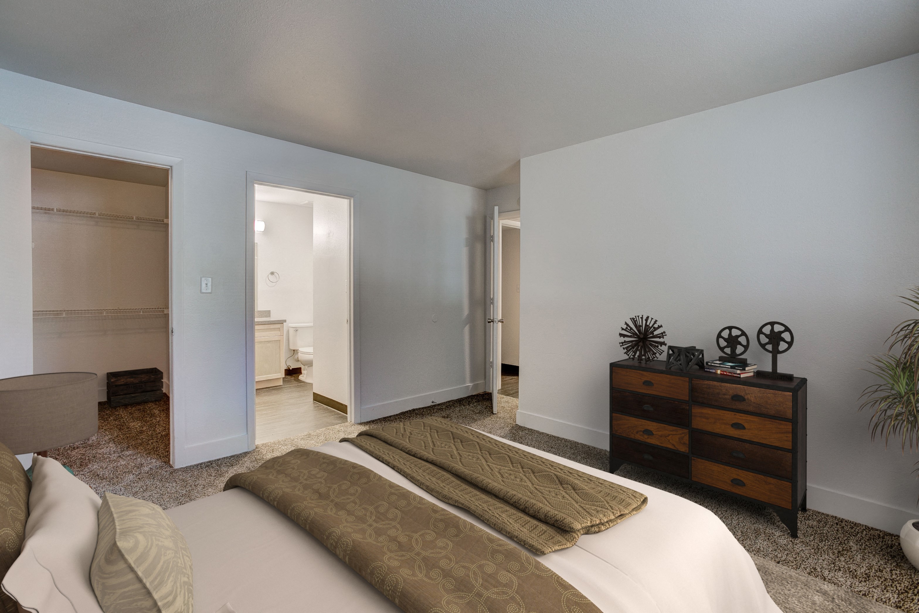 a bedroom with a bed and a dresser and a bathroom