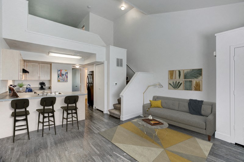a living room with a couch and a kitchen