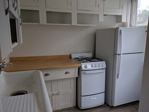 a small kitchen with a stove refrigerator and sink