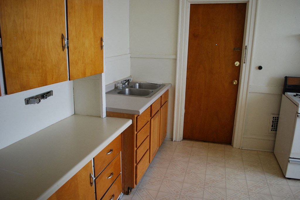 an empty kitchen with a sink and a door