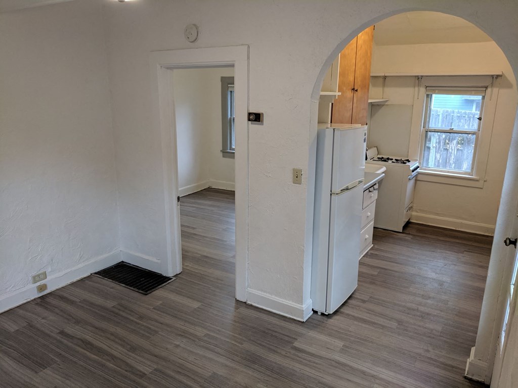 an empty kitchen and living room with a refrigerator