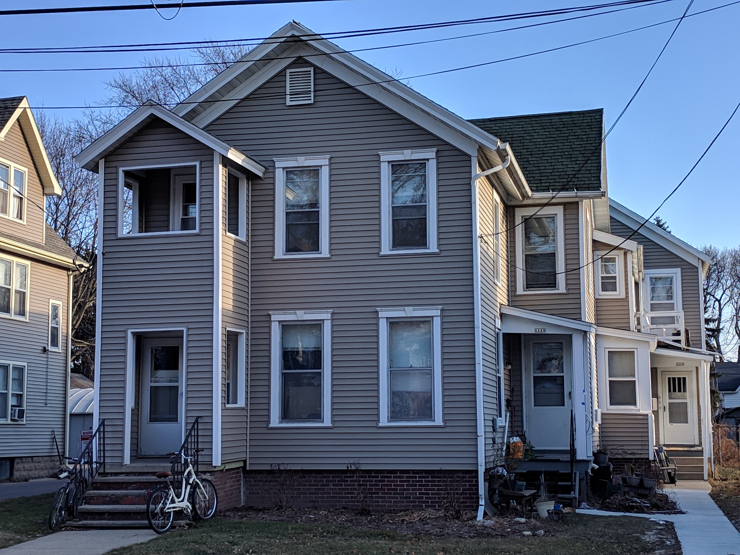 a gray house with a bike parked in front of it