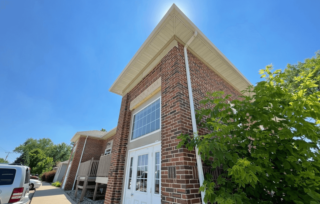 the front of a brick building with a white door