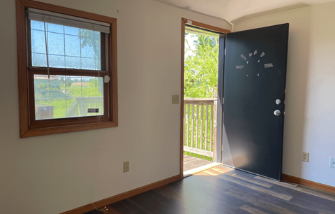 a room with a door and a window and a door to a balcony