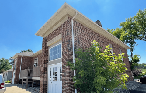 the front of a brick building with a white door