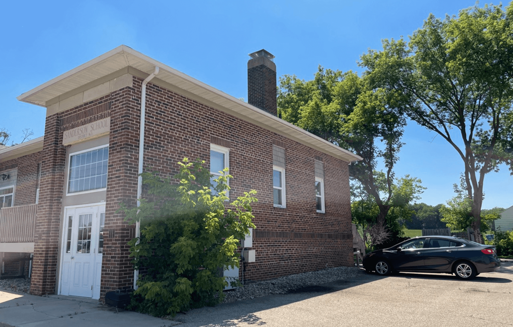 a brick building with a car parked outside of it