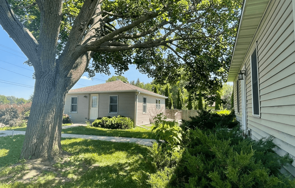 a white house with a tree in front of it