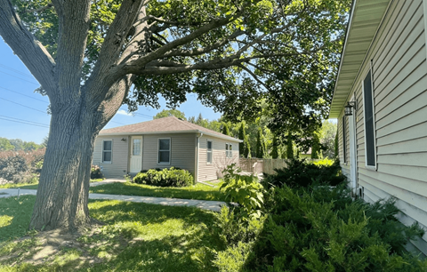 a white house with a tree in front of it