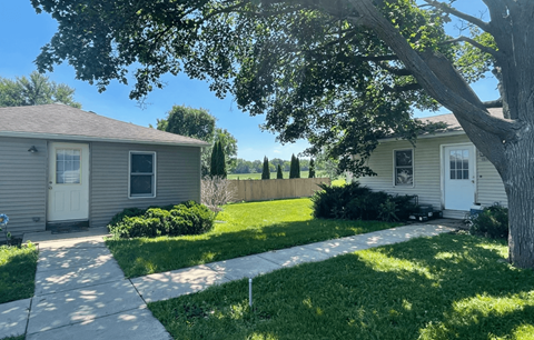 a small house with a yard and a tree