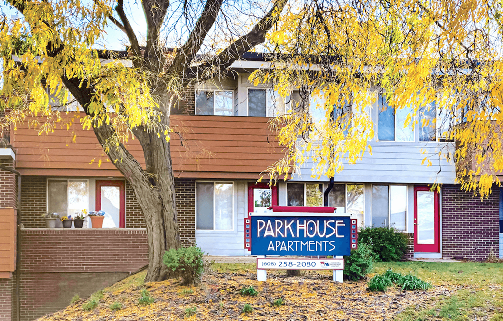 a park house apartments sign in front of a tree