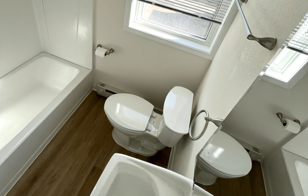 a small bathroom with two toilets and a sink