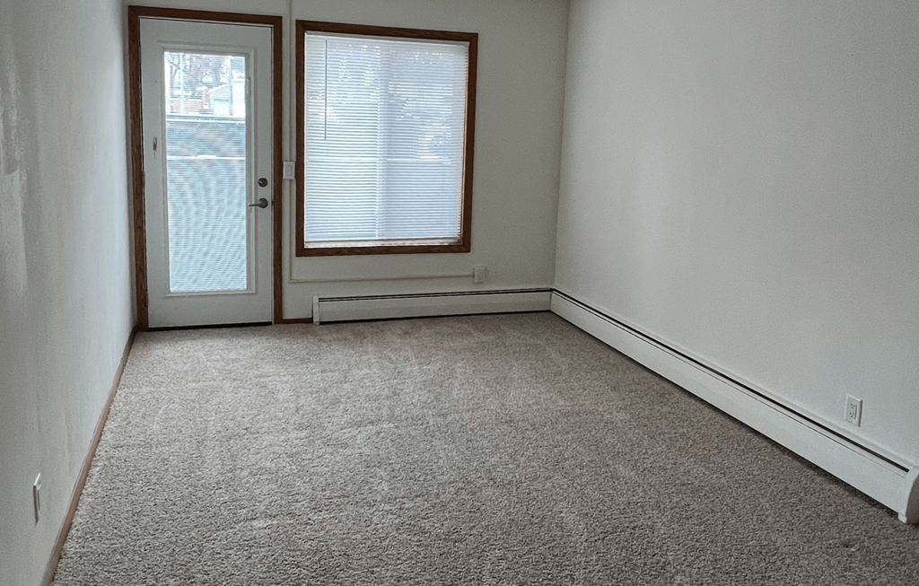 an empty room with a door and a window