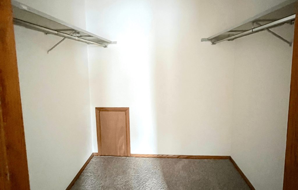 an empty room with a door to a closet
