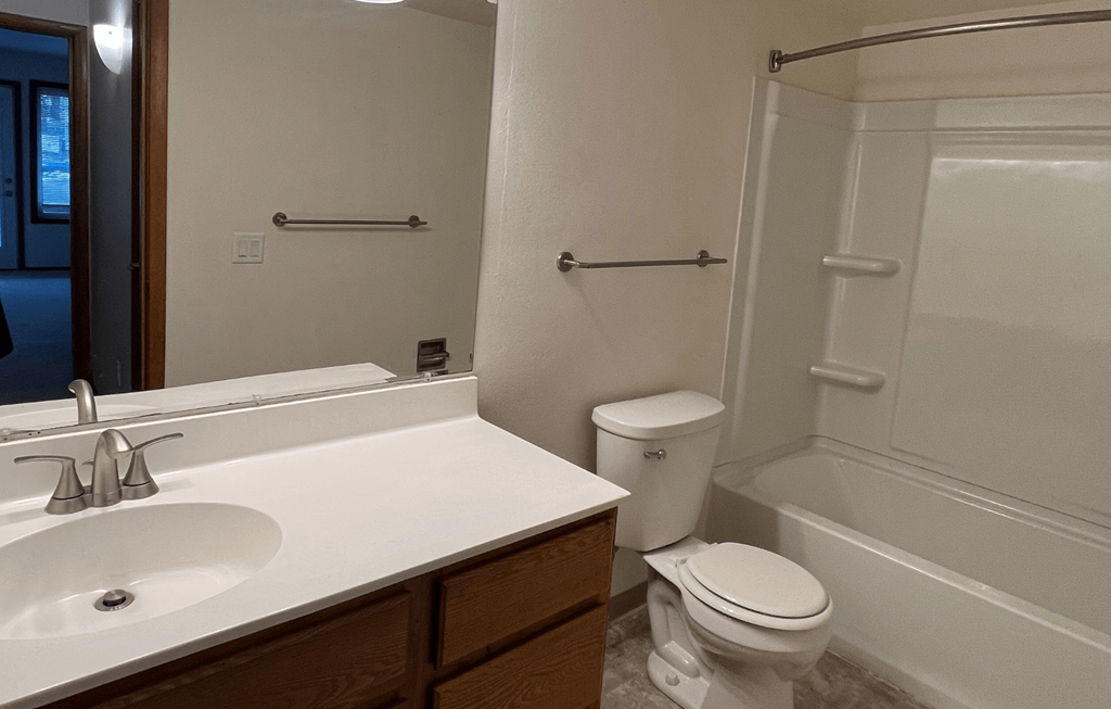 an empty bathroom with a sink toilet and shower