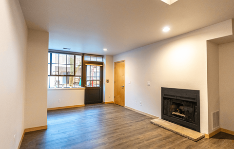 A living room with a fireplace and a large window.