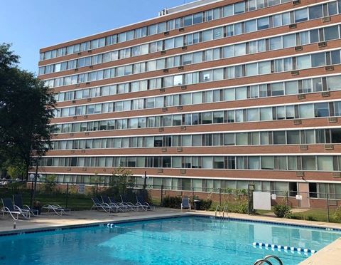 a swimming pool in front of a tall building