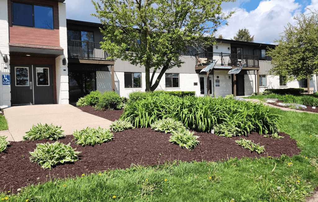 a garden in front of a building with a sidewalk