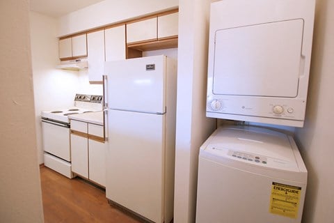 a kitchen with a washer and dryer and a refrigerator and a washing machine