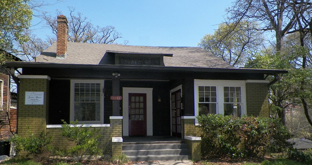 a small brick house with a red door