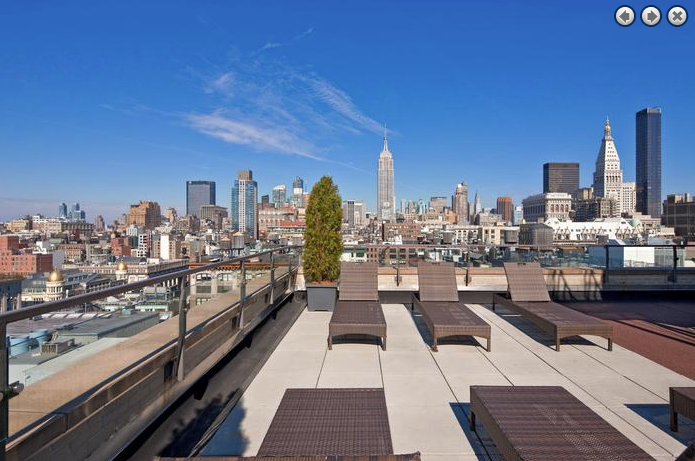 a group of benches on a roof overlooking a city