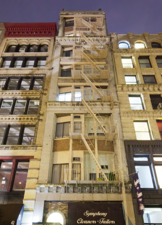 a group of tall buildings with fire escapes