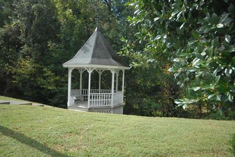 a gazebo in the middle of a grass field