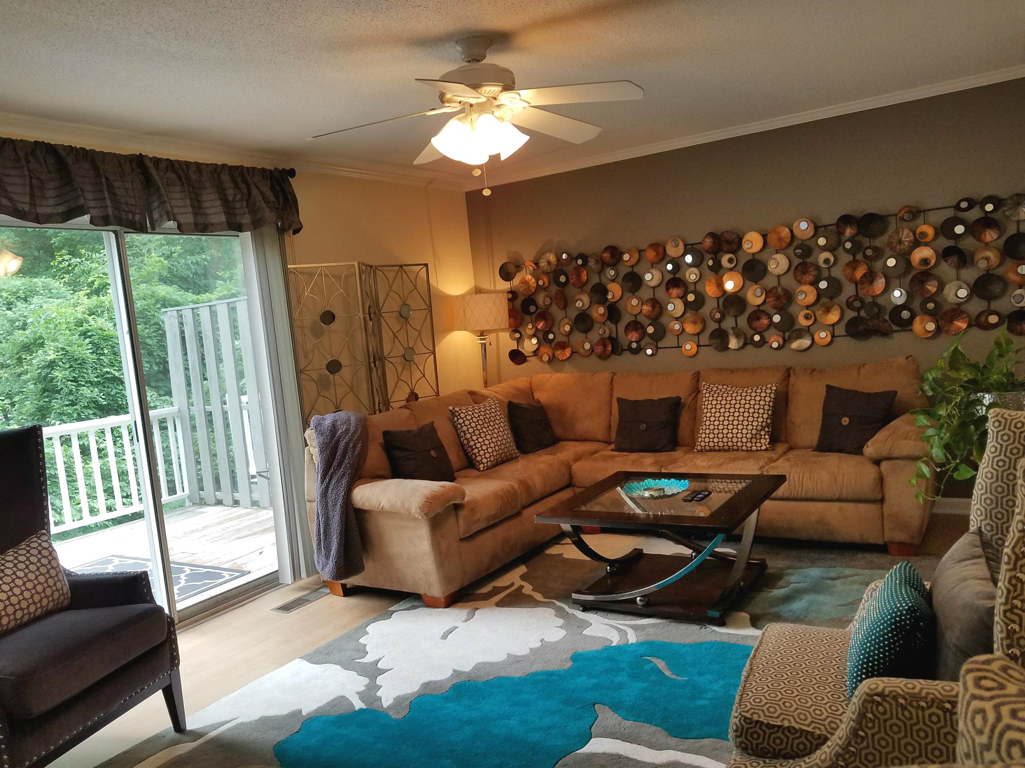 a living room with couches and chairs and a wall of pots and pans