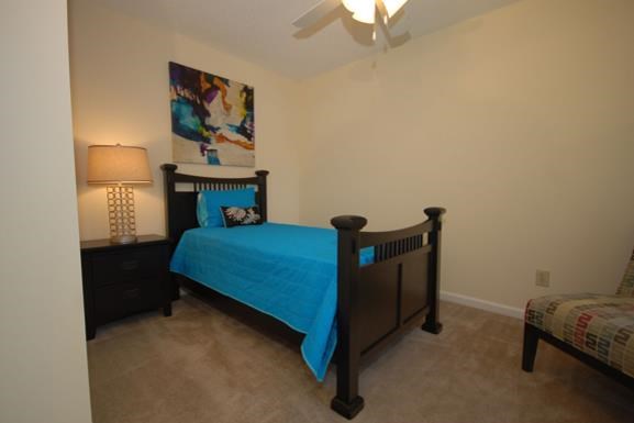 a bedroom with a bed and a ceiling fan