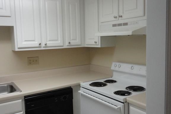 a kitchen with white cabinets and a stove and a sink