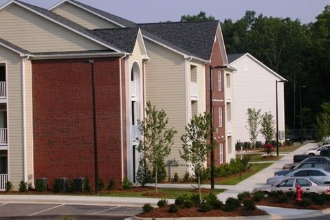a row of houses with cars parked in a parking lot
