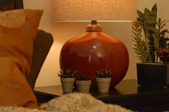 a table with a lamp and plants on it