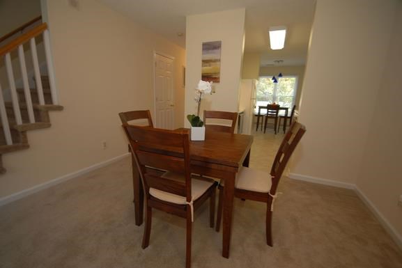 a dining room with a wooden table and chairs
