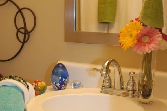a bathroom sink with a vase with flowers on it