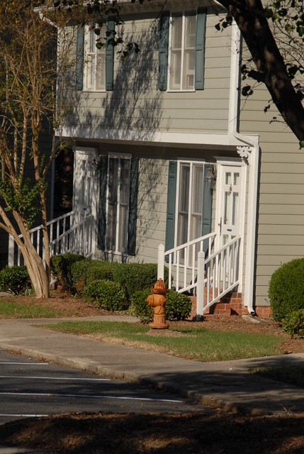 a yellow fire hydrant in front of a house
