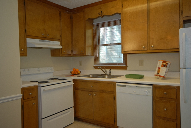 a kitchen with white appliances and wooden cabinets