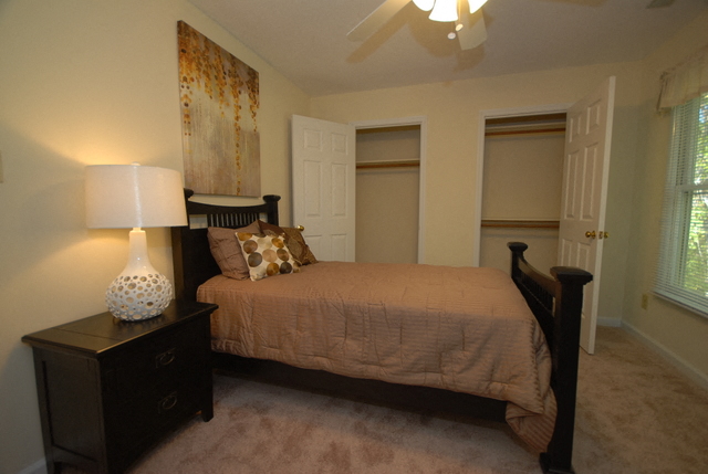 a bedroom with a bed and a night stand with a lamp