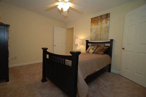 a bedroom with a bed and a ceiling fan