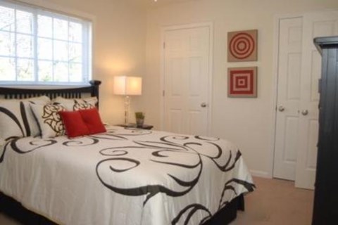 a bedroom with a black and white bed and a window