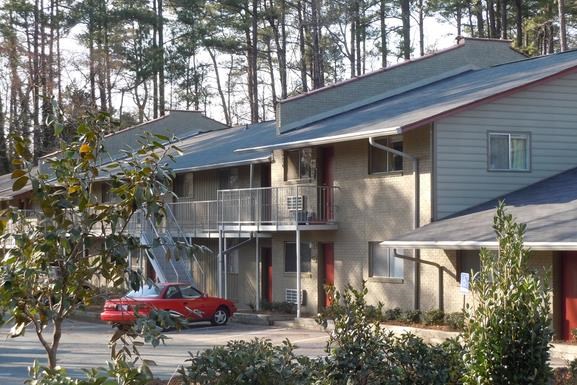 a house with a red car parked in front of it
